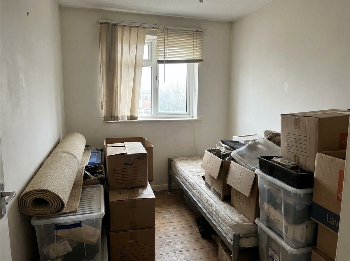 Cluttered spare room before conversion